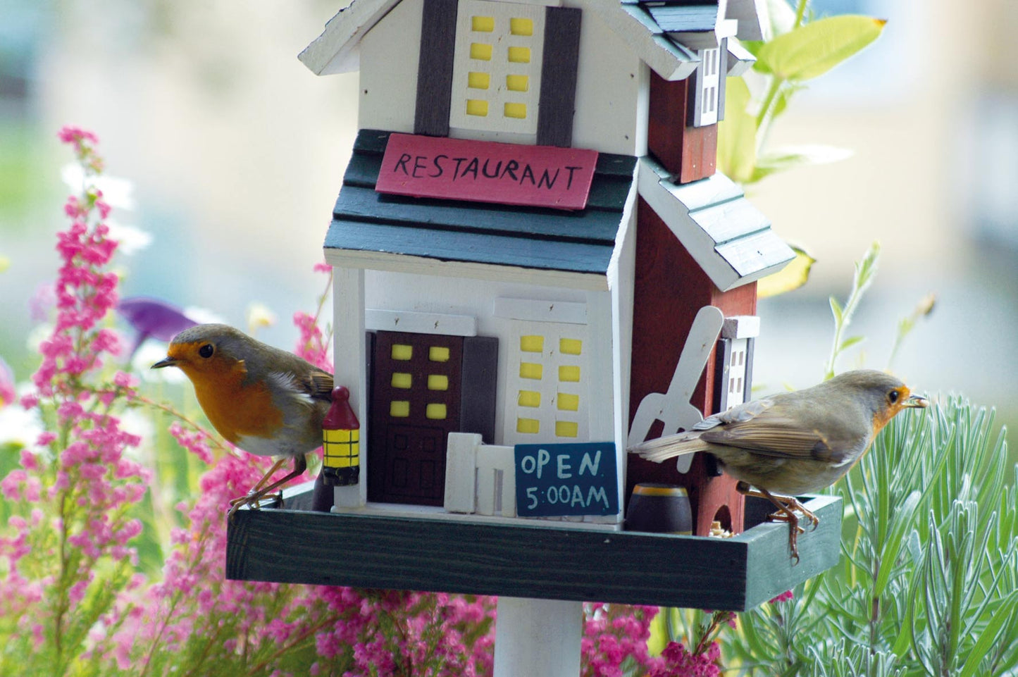 Handgefertigtes Vogelhaus mit farbenfrohem Western-Design und praktischem, leicht zu montierendem Ständer.