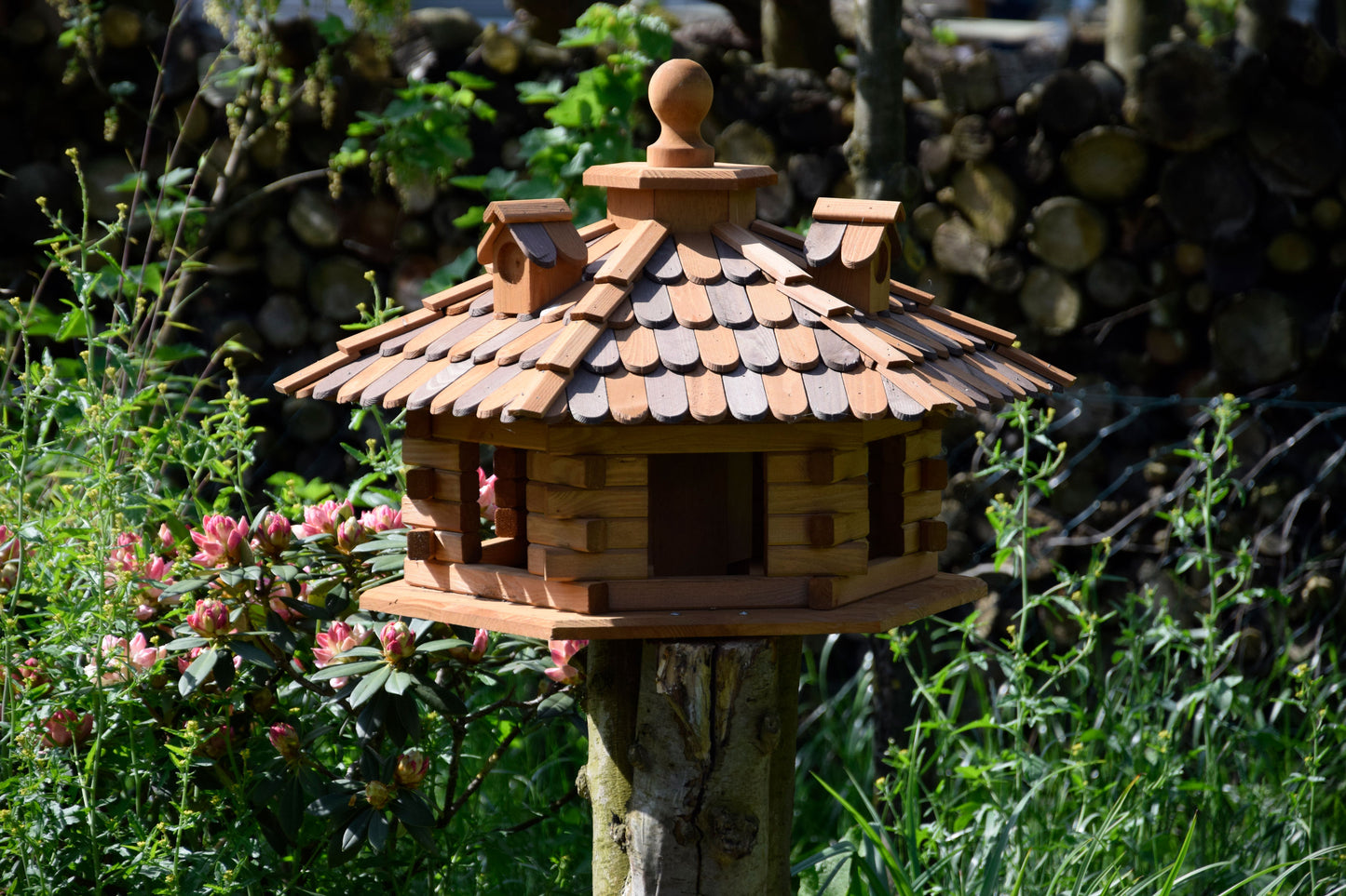 Sechseckiges XXL-Vogelfutterhaus im Blockhaus-Stil aus wetterfestem Kiefernholz mit Holzschindeldach, ideal für Wildvögel im Garten.