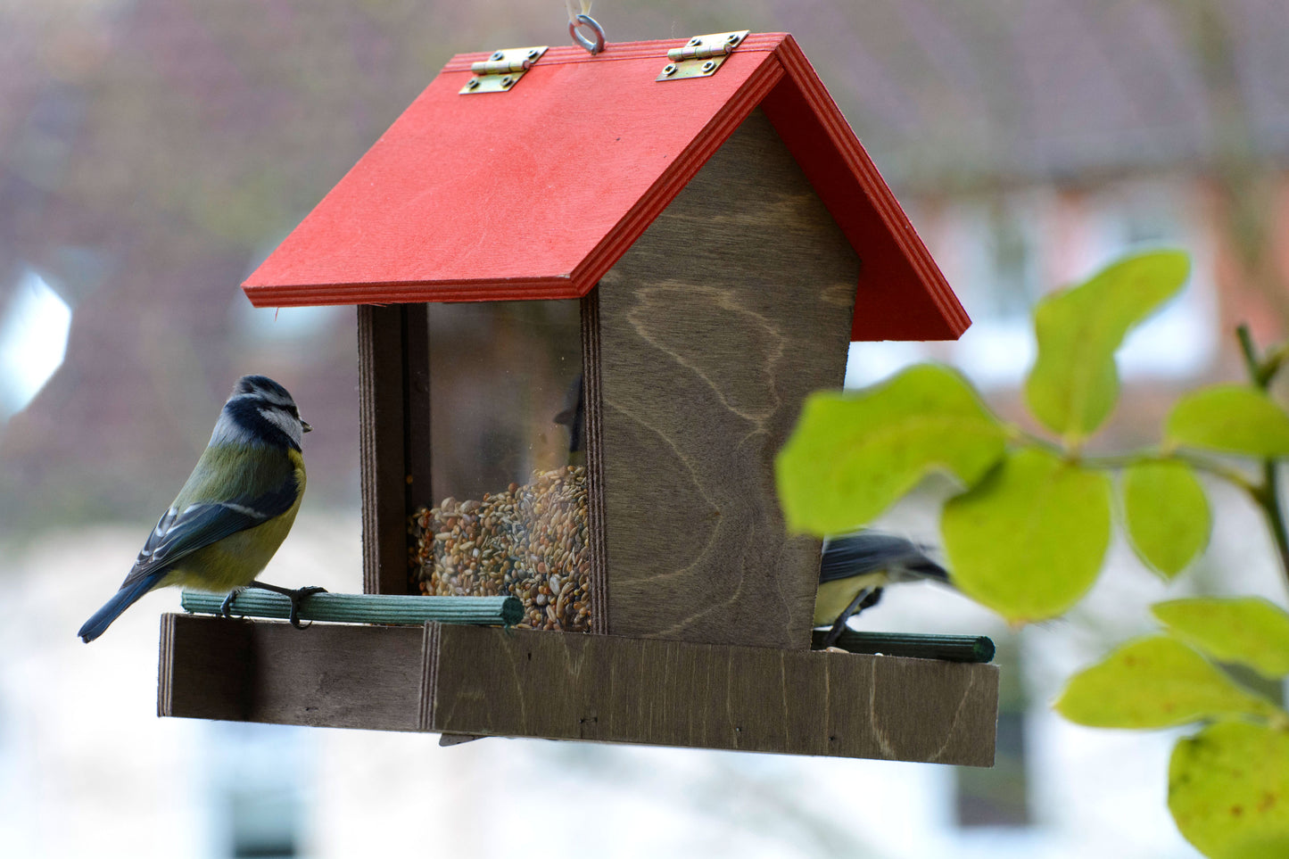 Kompakte Futterstation aus Holz – Hängendes Vogelhaus mit praktischem Design und einfachem Befüllungssystem.