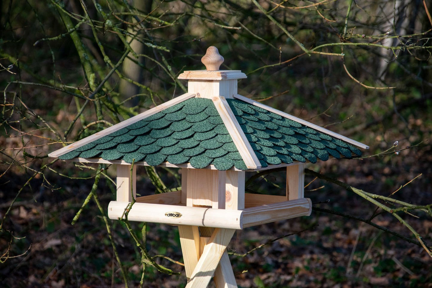 Handgefertigtes Vogelhaus mit grünem Bitumendach, schützt Vogelfutter vor Regen, ideal für einheimische Vögel.