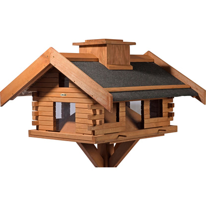 Detailansicht der Vogelvilla im rustikalen Berghütten-Design mit Futterpyramide für gleichmäßige Futterverteilung.
