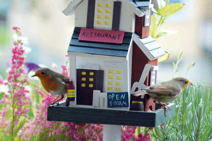 Handgefertigtes Vogelhaus mit farbenfrohem Western-Design und praktischem, leicht zu montierendem Ständer.
