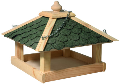 Aufgehängtes Vogelfutterhaus mit grünen Bitumenschindeln, ideal für Garten oder Balkon.
