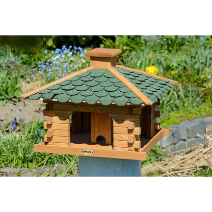 Rustikales Vogelhaus aus imprägniertem Kiefernholz mit grünem Bitumenschindeldach, perfekt für die Fütterung von Wildvögeln im Garten.