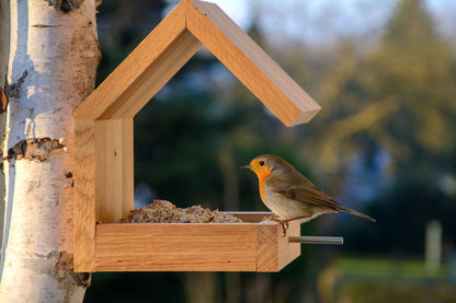 Handgefertigtes Vogelhaus aus massivem Eichenholz, ideal für die Fütterung von Wildvögeln, mit klaren Bauhaus-Formen.
