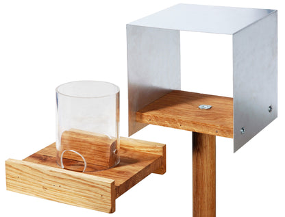 Detailansicht des minimalistischen Vogelfutterhauses im Bauhaus-Stil mit Acrylglassilo und herausziehbarem Futtertablett.
