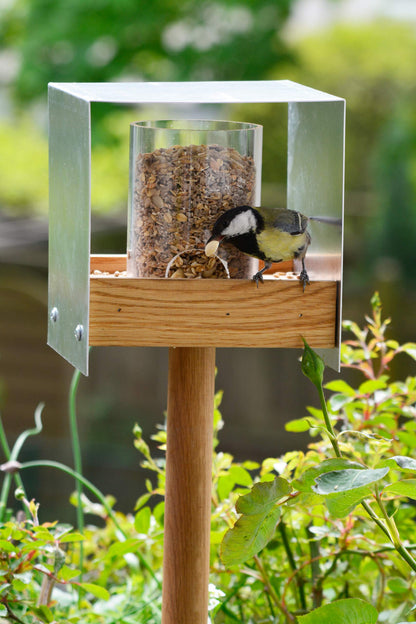 Handgefertigtes Design-Vogelfutterhaus mit klaren, funktionalen Linien, ideal für moderne Gartengestaltung.
