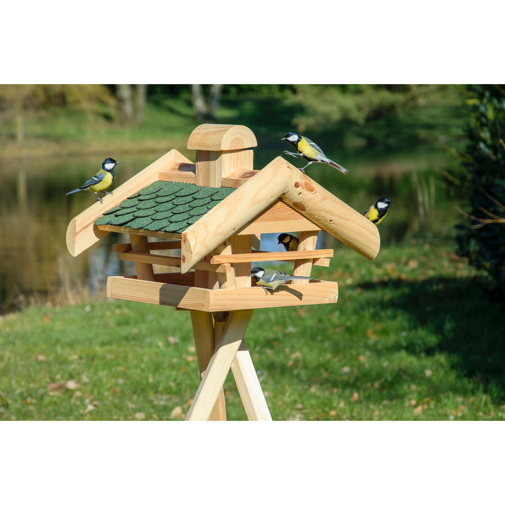 Wetterfestes Vogelfutterhaus aus massivem Holz mit integriertem Futtersilo und grünem Dach, schützt Futter vor Regen.